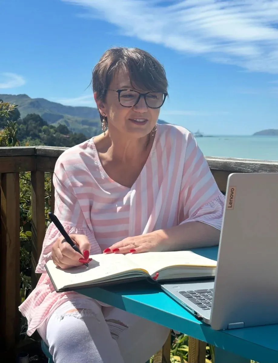 Lea-Anne writing a wedding ceremony outdoors on a sunny deck overlooking the water